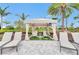 A poolside cabana with lounge chairs and a table offers a relaxing and private outdoor space amidst lush landscaping at 15707 Sacile Ln, Bradenton, FL 34211