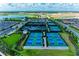 An aerial view showing the green and blue tennis courts and clubhouse in a residential community at 15707 Sacile Ln, Bradenton, FL 34211