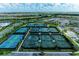An aerial view showing multiple tennis courts with lush landscaping in a residential community at 15707 Sacile Ln, Bradenton, FL 34211