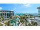 Aerial view of a luxury resort featuring pools, palm trees, beach, and ocean at 1591 Gulf Of Mexico Dr # 511, Longboat Key, FL 34228