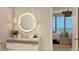 Bright bathroom features a modern vanity with a sleek, round mirror at 1591 Gulf Of Mexico Dr # 511, Longboat Key, FL 34228