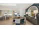 Open-concept dining area with round table, statement mirror, and a kitchen view at 1591 Gulf Of Mexico Dr # 511, Longboat Key, FL 34228