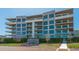 Luxury condo building with multiple floors, large windows, and private balconies with glass railings at 1591 Gulf Of Mexico Dr # 511, Longboat Key, FL 34228