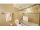 Bathroom featuring a bathtub with glass enclosure and neutral tile surround, along with matching towel bars at 19 Whispering Sands Dr # 805, Sarasota, FL 34242