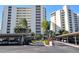 Condo building exterior with carport and tropical landscaping at 19 Whispering Sands Dr # 805, Sarasota, FL 34242