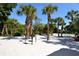 Outdoor community grilling area with picnic tables among palm trees and sandy ground at 19 Whispering Sands Dr # 805, Sarasota, FL 34242