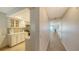 Hallway view leading to the kitchen with bright white cabinets and countertops and an ocean view in the distance at 19 Whispering Sands Dr # 805, Sarasota, FL 34242