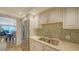 Bright kitchen features stainless steel appliances, light countertops, and tiled backsplash with a view of the dining area at 19 Whispering Sands Dr # 805, Sarasota, FL 34242