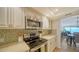 Bright kitchen with stainless steel appliances, white cabinets, and mosaic backsplash; open to dining area at 19 Whispering Sands Dr # 805, Sarasota, FL 34242