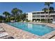 Community pool on a sunny day with palm trees, lounge chairs, and blue water at 19 Whispering Sands Dr # 805, Sarasota, FL 34242