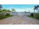 Inviting pool area with a decorative brick pathway leading to a fenced pool and ocean view at 19 Whispering Sands Dr # 805, Sarasota, FL 34242