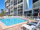 Large community pool with lounge chairs and building in the background on a bright, sunny day at 19 Whispering Sands Dr # 805, Sarasota, FL 34242