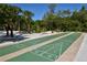 Outdoor shuffleboard courts surrounded by trees and greenery at 19 Whispering Sands Dr # 805, Sarasota, FL 34242