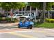 Street view of Siesta Key with shops and people driving a blue three wheeled vehicle at 19 Whispering Sands Dr # 805, Sarasota, FL 34242