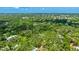 Expansive aerial view of a neighborhood with lush greenery; the home sits on a wooded lot at 2061 Misty Sunrise Trl, Sarasota, FL 34240