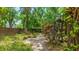 Lush backyard featuring mature trees and landscaping around the screened-in pool at 2061 Misty Sunrise Trl, Sarasota, FL 34240