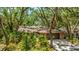 Charming single-story home with lush landscaping and mature trees offering shade and privacy at 2061 Misty Sunrise Trl, Sarasota, FL 34240
