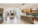 Spacious kitchen with breakfast bar area flowing into the living room with a brick fireplace at 2061 Misty Sunrise Trl, Sarasota, FL 34240