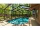 Enjoy a refreshing dip in this screened-in pool surrounded by lush landscaping at 2061 Misty Sunrise Trl, Sarasota, FL 34240