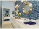 Stylish bathroom with dual sinks, white cabinets, and a beautiful blue tiled wall at 21225 Wacissa Dr, Venice, FL 34293
