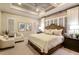 Serene bedroom with a tray ceiling, neutral tones, plantation shutters, and comfortable furnishings at 21225 Wacissa Dr, Venice, FL 34293
