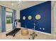 Home gym with treadmill and bike, accented by navy blue wall with decorative clocks at 21225 Wacissa Dr, Venice, FL 34293