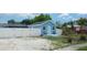 Light blue cottage with white trim, a green roof, a small front porch, and a white fence at 21403 Glendale Ave, Port Charlotte, FL 33952