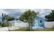 Light blue home and cottage with white fence and palm trees at 21403 Glendale Ave, Port Charlotte, FL 33952