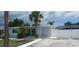 Charming single-story light blue home featuring palm trees, accent stone, and a white fence at 21403 Glendale Ave, Port Charlotte, FL 33952
