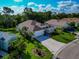Aerial view of a home on a well-manicured corner lot with lovely landscaping and a two-car garage at 230 Fareham Dr, Venice, FL 34293
