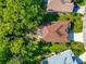 Aerial top-down view of a beautiful property featuring lush landscaping, a screened lanai, and mature trees at 230 Fareham Dr, Venice, FL 34293