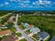 Aerial view of colorful homes on a quiet street, with lush landscaping and a community pool in the neighborhood at 230 Fareham Dr, Venice, FL 34293