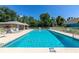 Inviting community pool with ample lounge chairs, a covered pavilion, and lush green surroundings perfect for relaxation at 230 Fareham Dr, Venice, FL 34293