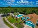 Aerial view of a vibrant blue home with a screened pool, beautifully landscaped yard, and a serene community setting at 230 Fareham Dr, Venice, FL 34293