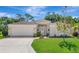 Charming single-story home with a well-manicured lawn, attached garage, and inviting front entrance at 230 Fareham Dr, Venice, FL 34293