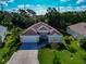 An attractive single-story home featuring a manicured lawn, an attached garage, and a welcoming entrance at 230 Fareham Dr, Venice, FL 34293