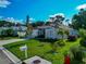 Well-maintained single-story home with lush green lawn, mature trees, and vibrant landscaping offering great curb appeal at 230 Fareham Dr, Venice, FL 34293