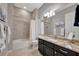 Bathroom with granite countertops, dark cabinets, tile floors, and shower over tub at 23233 Banbury Way # 302, Venice, FL 34293