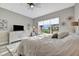 Bedroom with ceiling fan, dresser, television, and large windows with a scenic view at 23233 Banbury Way # 302, Venice, FL 34293