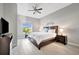 Bedroom with light grey walls, ceiling fan, exterior window, tile flooring, and wood furniture at 23233 Banbury Way # 302, Venice, FL 34293