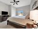 Bedroom features neutral walls, ceiling fan, and an exterior window overlooking the neighborhood at 23233 Banbury Way # 302, Venice, FL 34293