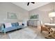 Cozy den with a blue sofa, desk, and neutral decor at 23233 Banbury Way # 302, Venice, FL 34293