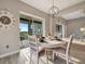 Dining area with round table, chandelier, scenic views, and access to outdoor space at 23233 Banbury Way # 302, Venice, FL 34293
