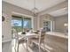 Dining area featuring a round table, chandelier, and access to the lanai with scenic views at 23233 Banbury Way # 302, Venice, FL 34293