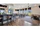 Spacious dining room with hardwood floors, a modern bar, and ample seating with scenic views at 23233 Banbury Way # 302, Venice, FL 34293