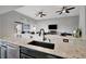 Kitchen island overlooking the living room with marble countertops and stainless steel dishwasher at 23233 Banbury Way # 302, Venice, FL 34293