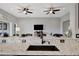 Modern kitchen with island and sink overlooking living area, with dark cabinetry and marble countertops at 23233 Banbury Way # 302, Venice, FL 34293