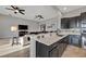 Modern kitchen open to the living room, featuring dark cabinetry and bar seating at 23233 Banbury Way # 302, Venice, FL 34293