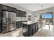 Modern kitchen with stainless steel fridge, dark cabinets, an island, and an adjacent dining area at 23233 Banbury Way # 302, Venice, FL 34293