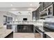 Modern kitchen featuring stainless steel appliances, granite counters, mosaic backsplash, and dark cabinets at 23233 Banbury Way # 302, Venice, FL 34293